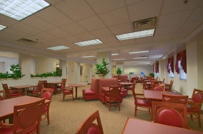 Dining area with tables and seating in a senior living facility