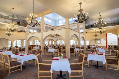 Bright dining room with elegant chandeliers and tables set