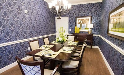 Elegant dining room with floral centerpiece and patterned walls
