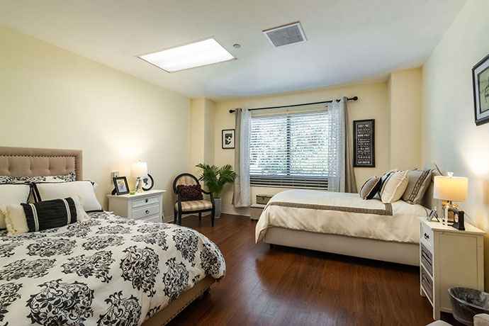 Comfortable resident room with two beds and natural light