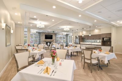 Bright dining room with set tables and flowers