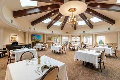Elegant dining room with tables set for residents