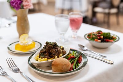 A beautifully plated meal with salad and dessert