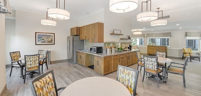 Bright interior common area with kitchen and dining tables