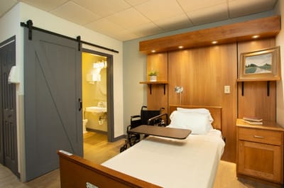 A private resident room with a bed and wheelchair