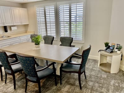 Brightly lit meeting room with a large table and chairs