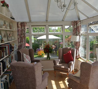 Bright and inviting sunroom with armchairs and flowers