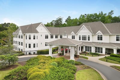 Exterior view of a senior living facility with landscaped gardens