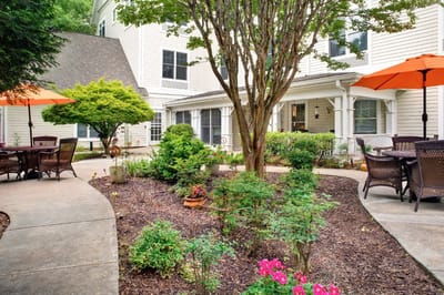 A serene garden courtyard with seating and umbrellas