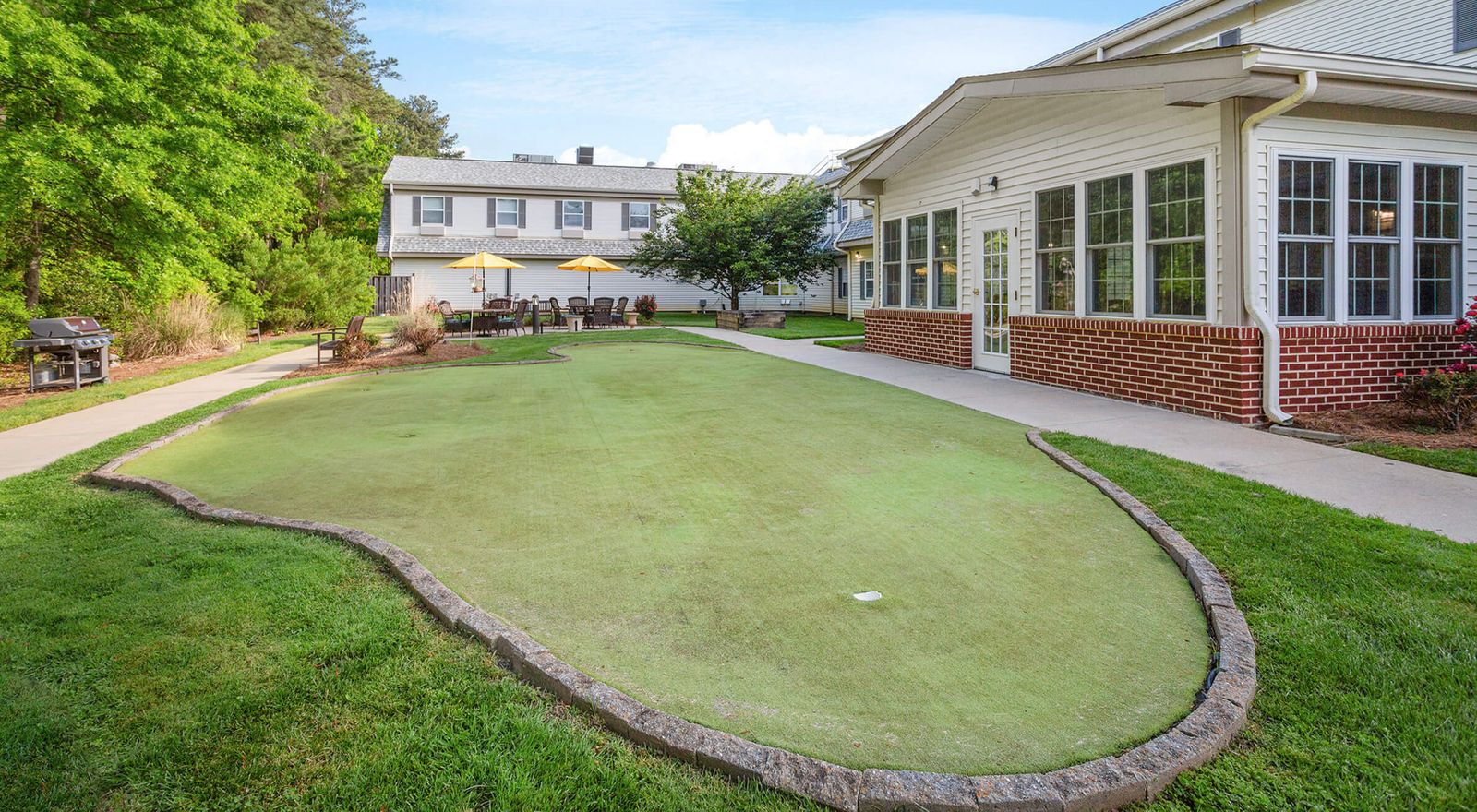 An outdoor area with a green space and seating.