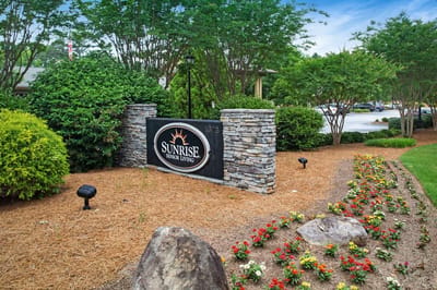 Exterior sign for Sunrise Senior Living with landscaping