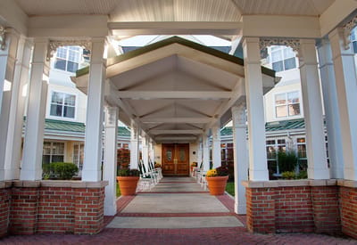Covered entrance with seating and potted plants