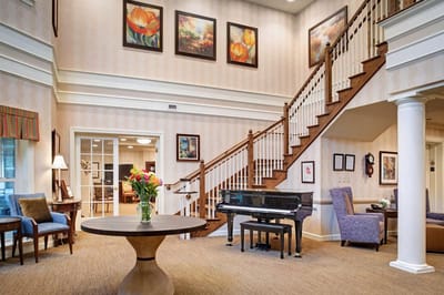Bright interior of a common area with piano and artwork
