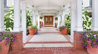 Well-lit entrance of a senior living facility with flowers