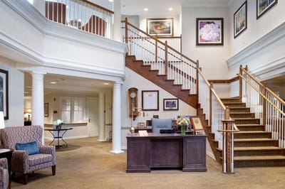 Bright lobby area with elegant staircase and furniture