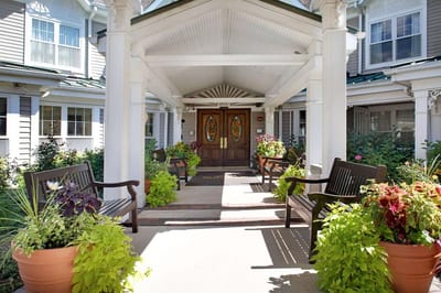 Entrance of a senior living facility with planters and benches