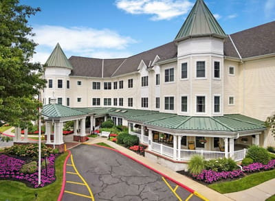 Exterior view of a senior living facility surrounded by flowers