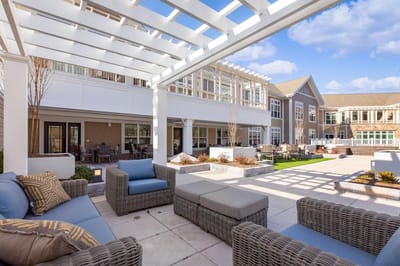 Outdoor seating area with a pergola and green space