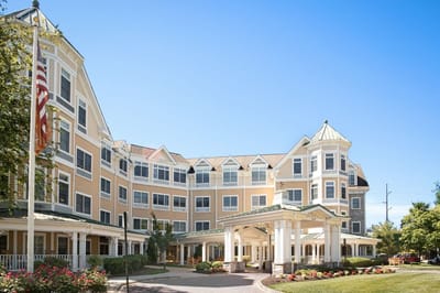 Exterior view of a senior living facility with gardens