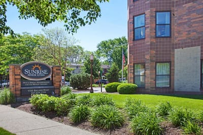 Exterior view of Sunrise Senior Living facility with sign