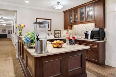 Bright kitchen area with a fruit bowl and flowers