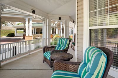 Covered porch area with wicker furniture and cushions