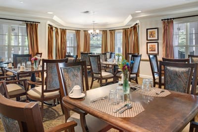 Dining area set for residents with flowers on tables