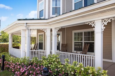 Outdoor seating area with rocking chairs and flower beds