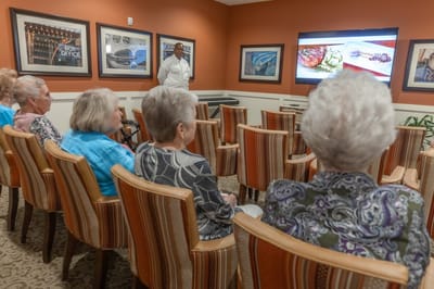 Residents enjoying a presentation in a common area