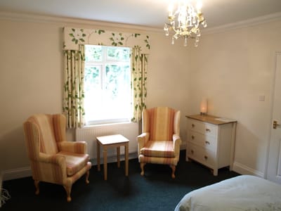 Cozy resident room with two armchairs and a dresser