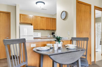 A cozy kitchen area with a dining table set for two