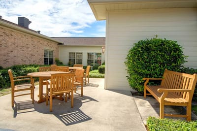Outdoor seating area with wooden furniture and greenery