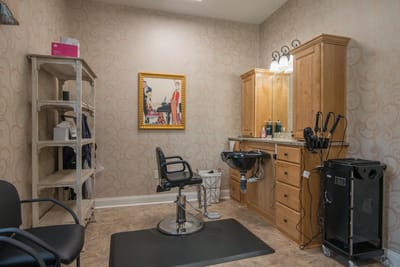 Bright salon area with a styling chair and cabinetry