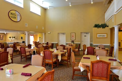 Bright dining room with tables and chairs set up for meals