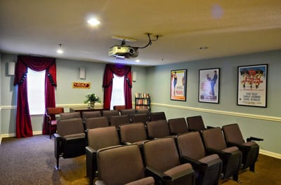 A movie theater room with seating and posters