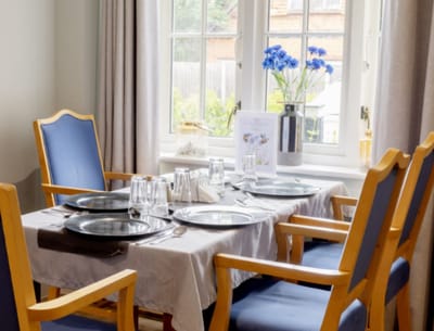 Dining area set for a meal with flowers