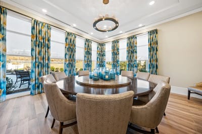 Bright dining room with decorative curtains and round table