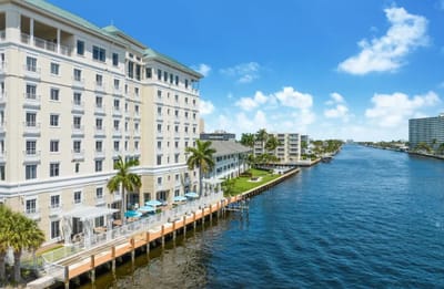 Exterior view of a senior living facility by a waterway