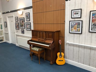 An interior common area with a piano and guitar