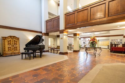 Interior view of a senior living common area with a piano