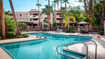 Serene outdoor pool area with palm trees and seating