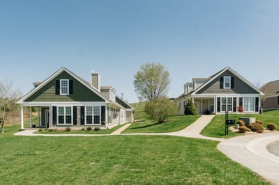 Two residential buildings in a green outdoor space