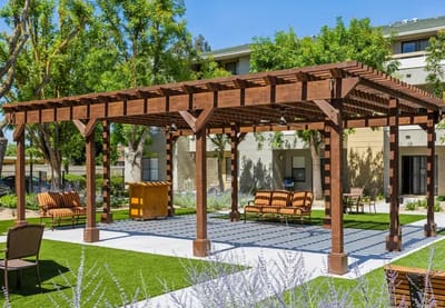 Outdoor pergola with seating area in a senior living facility