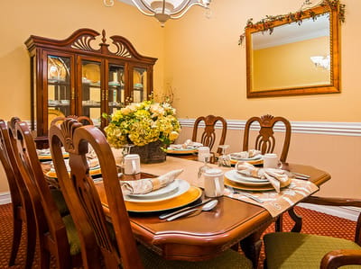 Dining room set for a meal with flowers on the table