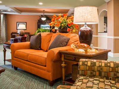 Cozy living room area with orange sofa and decorative flowers