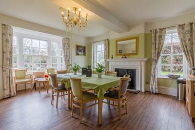 Bright dining room with plants and a chandelier