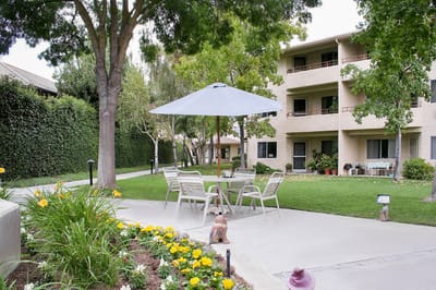 Outdoor seating area with garden in a senior living facility