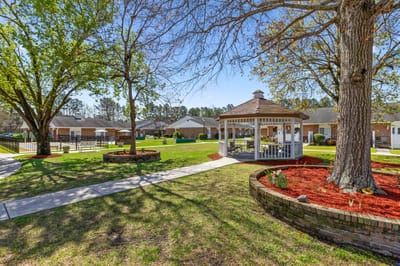 A peaceful outdoor area with a gazebo and green lawn