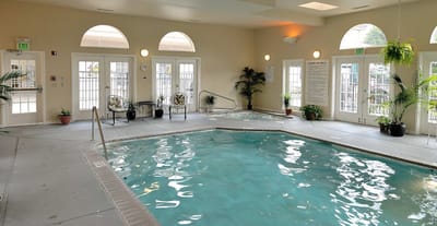 Indoor swimming pool area with seating and plants
