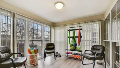 Bright sunroom with exercise equipment and seating
